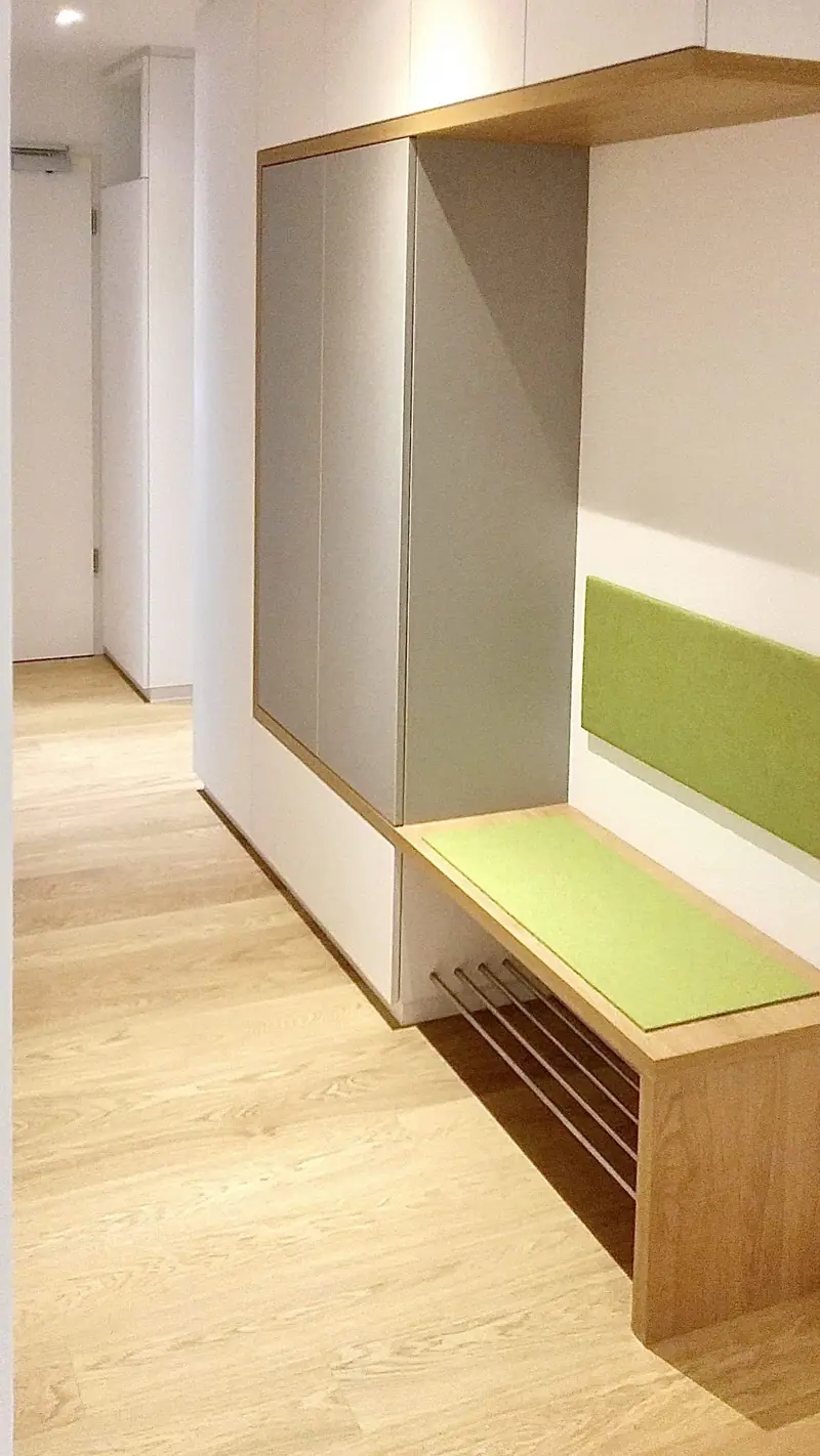 Flur mit Garderobe, Sitzbank und Holzelement